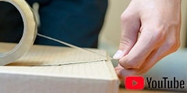 Imagen de una persona comenzando a sellar con cinta una caja de cartón corrugado.

