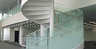 A glass railing, which follows a spiral staircase up to the second floor of a government building, has a frosted look with 3MTM Decorative Films.
