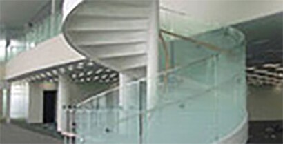 A glass railing, which follows a spiral staircase up to the second floor of a government building, has a frosted look with 3MTM Decorative Films.
