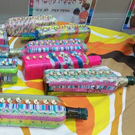 Recycled bottles decorated with brightly colored tape.