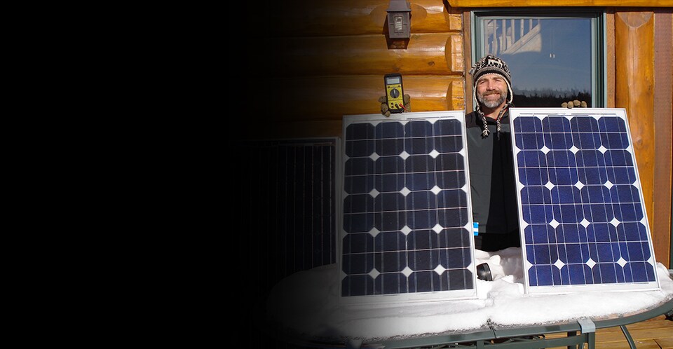 3M scientist Tim Hebrink holding the solar panels that have helped him generate about 80 percent of his home&rsquo;s energy.