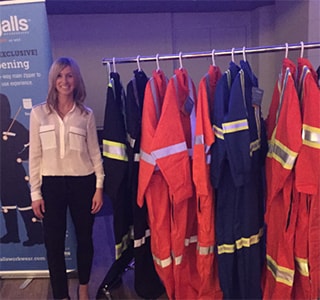 Alicia Woods, founder of Covergalls, standing near a rack of her product