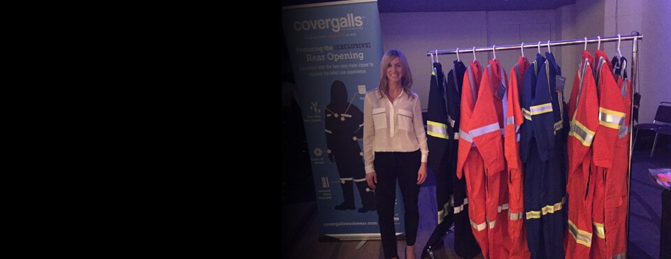 Alicia Woods, founder of Covergalls, standing near a rack of her product
