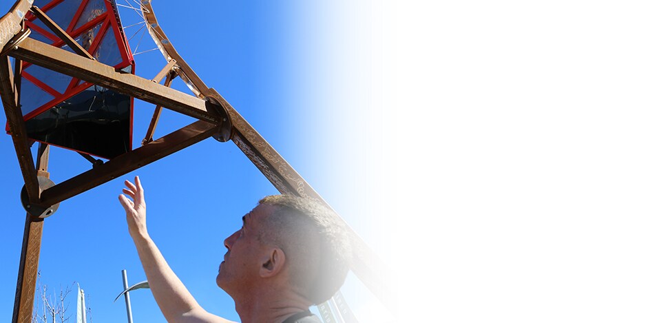 Artist, Philip Blackburn, stands next to his 22-foot kaleidoscope sculpture.