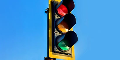Highly visible stoplight against blue sky.
