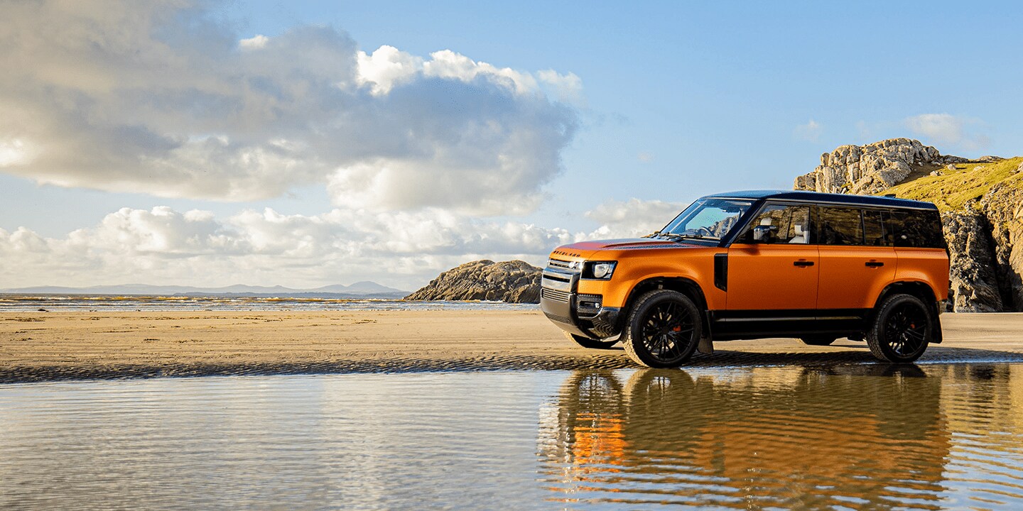 Orange film wrap SUV on beach
