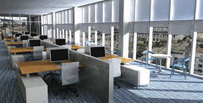 An open office space with a wall of windows promises comfort.
