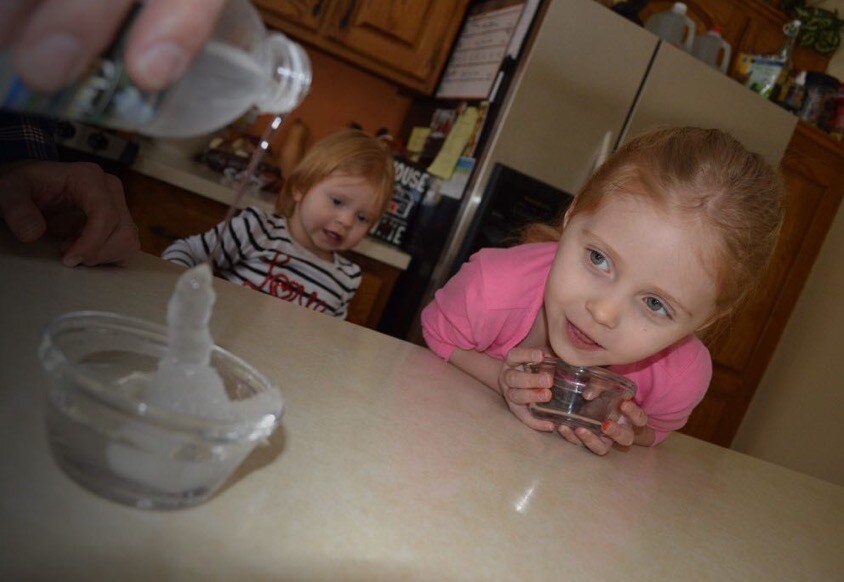 3-year-old Addison watches with curiosity joy as her father, 3M Chemist Korey Karls, demonstrates a kitchen science experiment