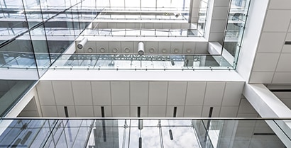 Office building windows look out over a sunny atrium.
