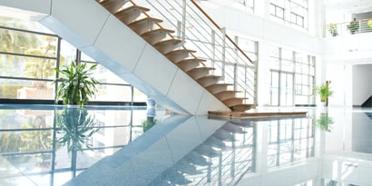 Una escalera y su reflejo en el piso pulido.
