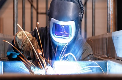 Workman in welding helmet.